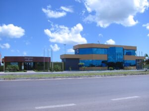 Prédio da Prefeitura e Câmara Municipal de Capivari do Sul, com fachada moderna de vidro azul sob céu ensolarado
