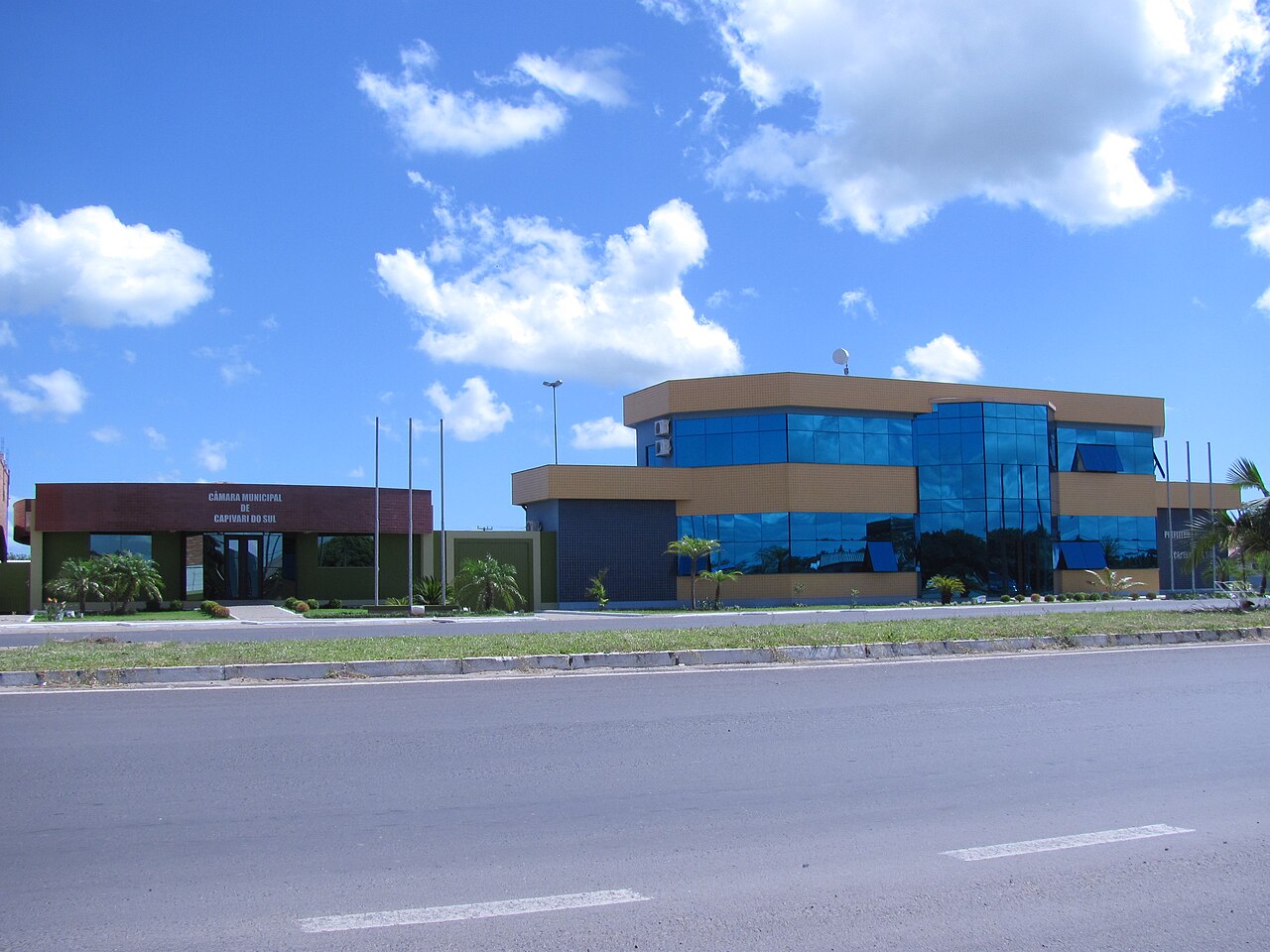 Prédio da Prefeitura e Câmara Municipal de Capivari do Sul, com fachada moderna de vidro azul sob céu ensolarado